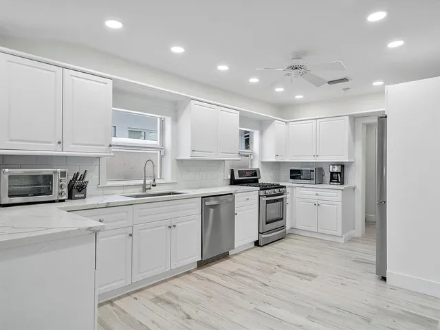 a kitchen with white cabinets stainless steel appliances and sink
