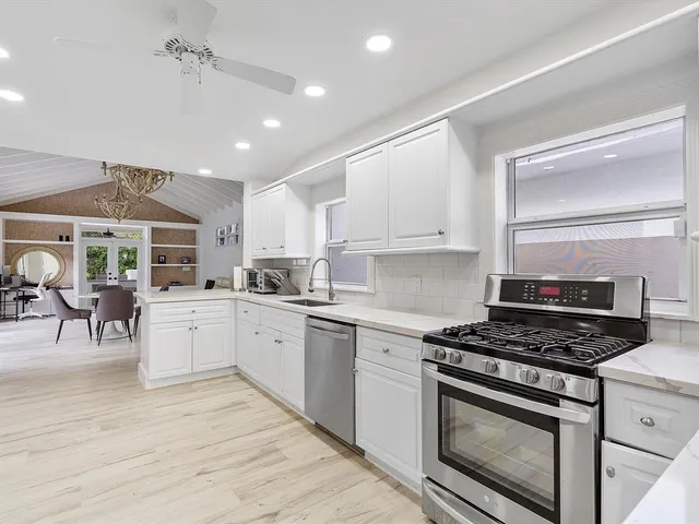 a kitchen with white cabinets and appliances