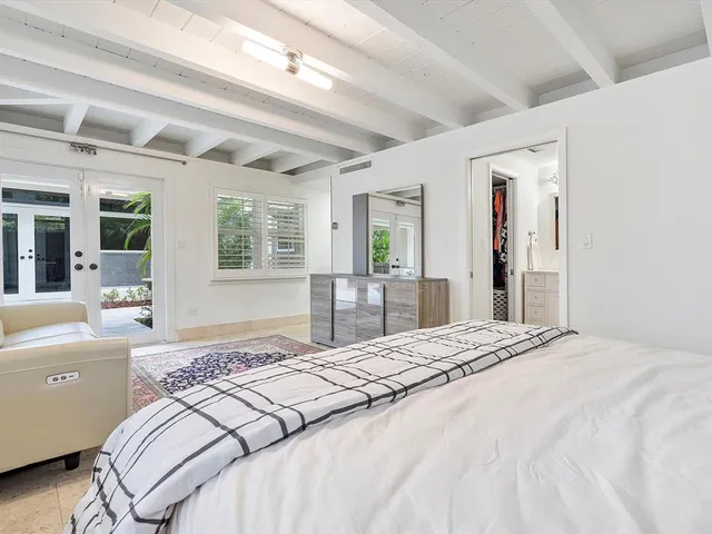 a bedroom with a large bed and a window