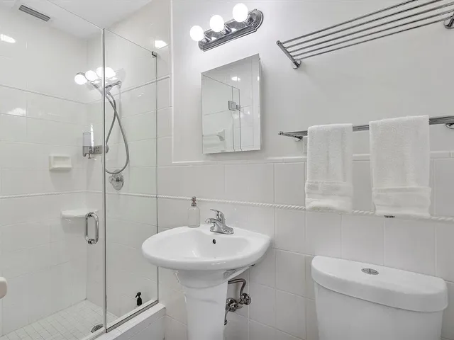 a bathroom with a sink a toilet and shower