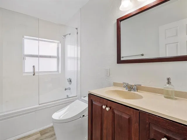 a bathroom with a sink a toilet and shower