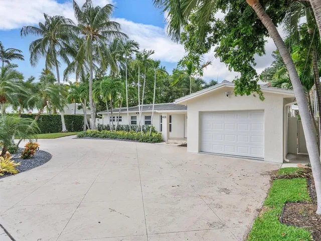 a view of a house with a yard and coconut trees