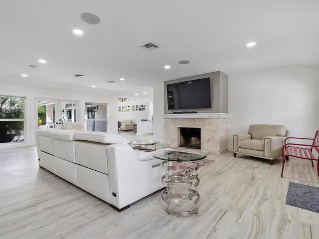 a living room with furniture a fireplace and a flat screen tv