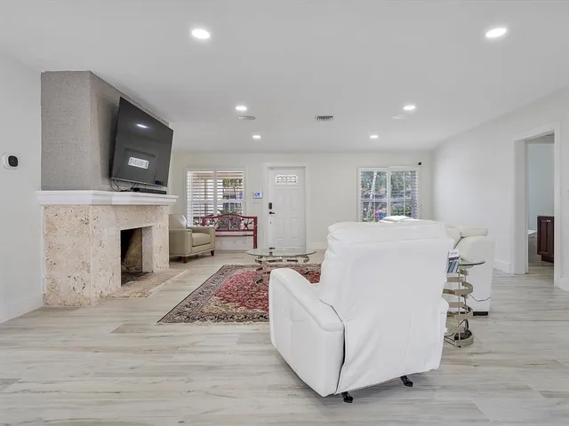 a living room with furniture a fireplace and a flat screen tv