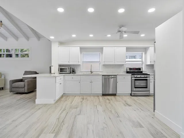 a kitchen with stainless steel appliances granite countertop a stove a sink and a refrigerator