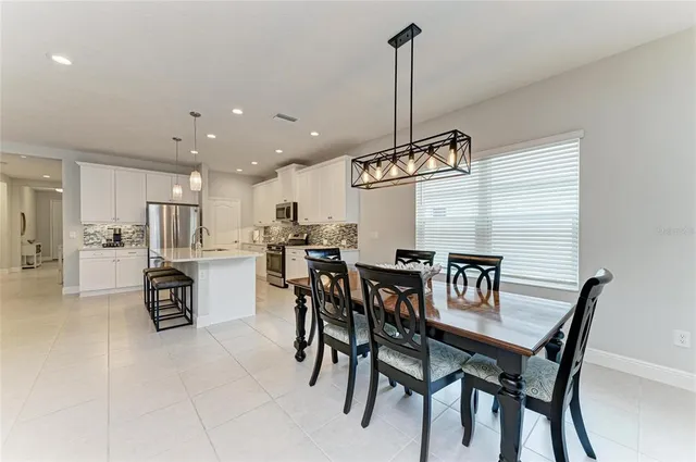 a dining room with furniture a chandelier and window