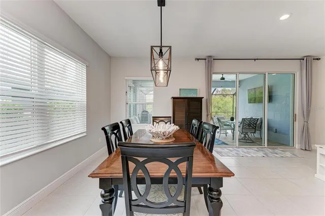 a kitchen with stainless steel appliances a stove a sink a oven a dining table and chairs