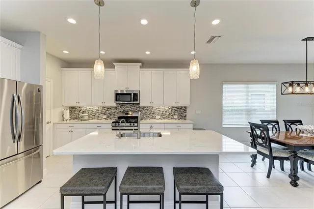 a kitchen with stainless steel appliances a sink stove and refrigerator