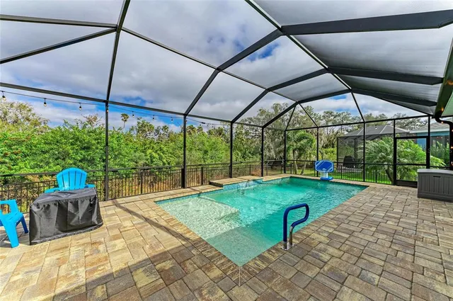 a view of a yard with a table and chairs under an umbrella