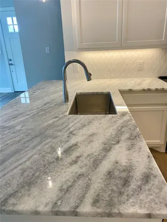 a view of kitchen with stainless steel appliances kitchen island wooden floor and living room view
