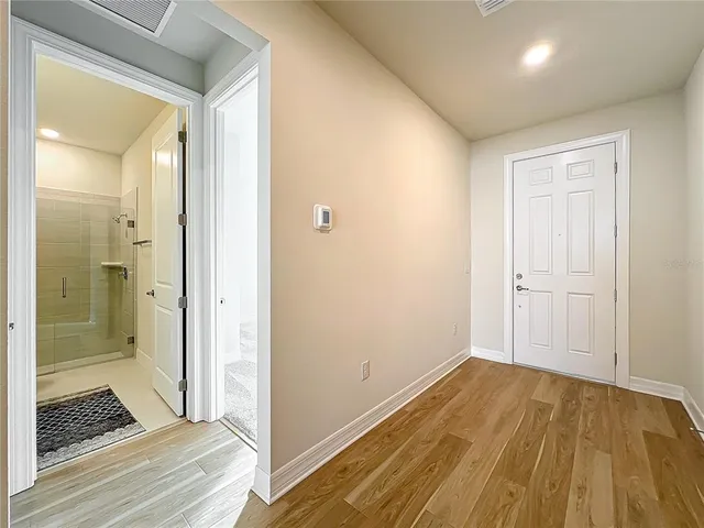 a view of an empty room with kitchen and kitchen counter top space