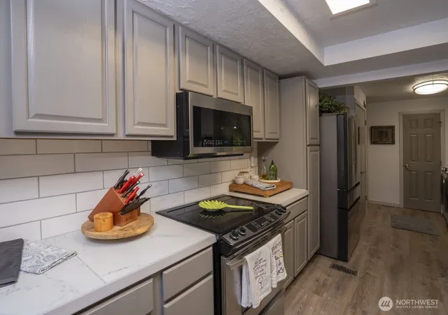 a kitchen with stainless steel appliances a stove a sink and a refrigerator