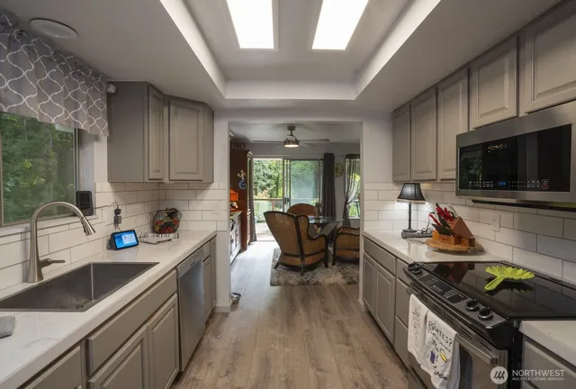 a kitchen with a sink a stove and a microwave oven