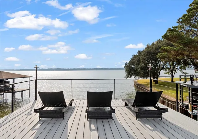 a view of a balcony with wooden floor and outdoor seating