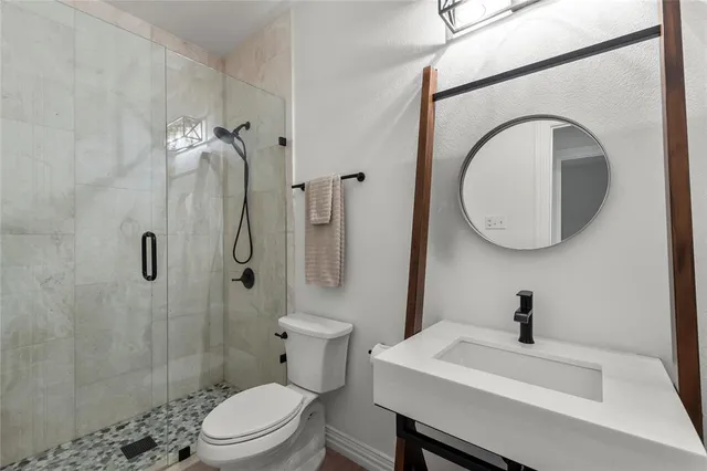 a bathroom with a toilet a sink and a mirror