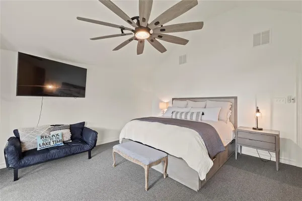 a bedroom with a bed a couch and a flat screen tv