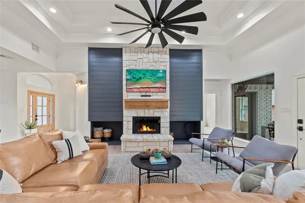 a living room with furniture a fireplace and a large window