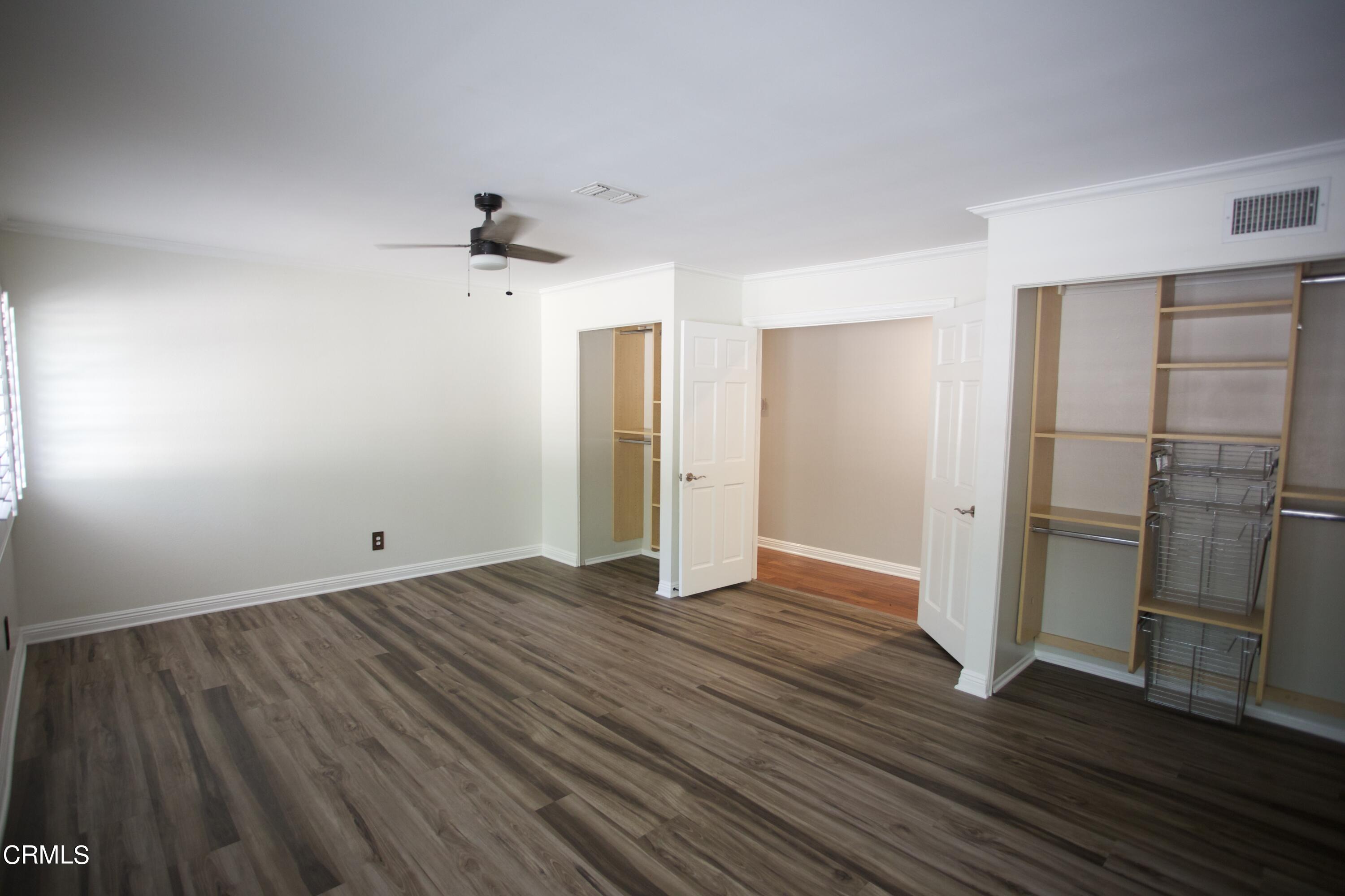 7438 Alpine Way Tujunga, CA 91042 - Photo 15 of 30 an empty room with wooden floor ceiling fan and windows