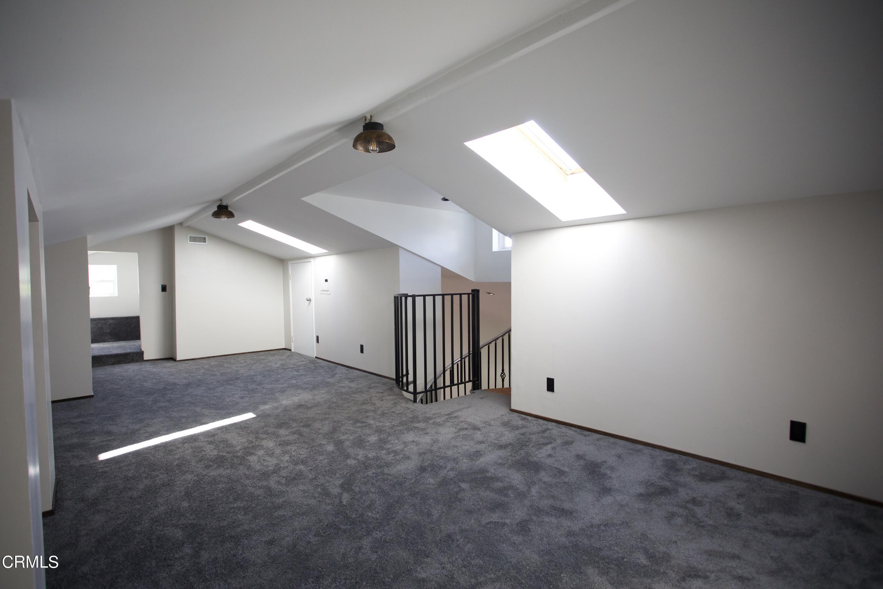 7438 Alpine Way Tujunga, CA 91042 - Photo 17 of 30 en empty room with windows and ceiling fan