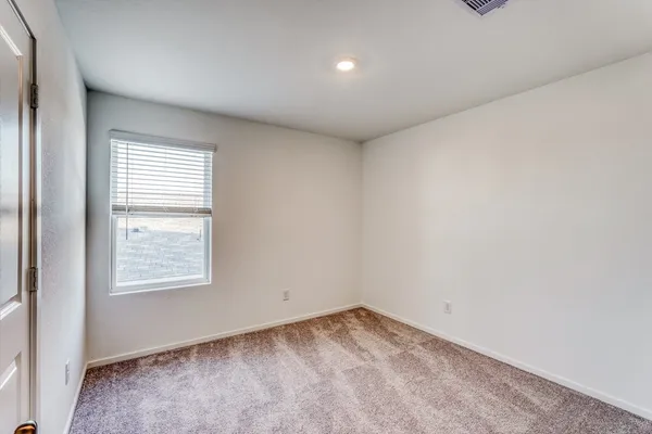 an empty room with windows and ceiling fan