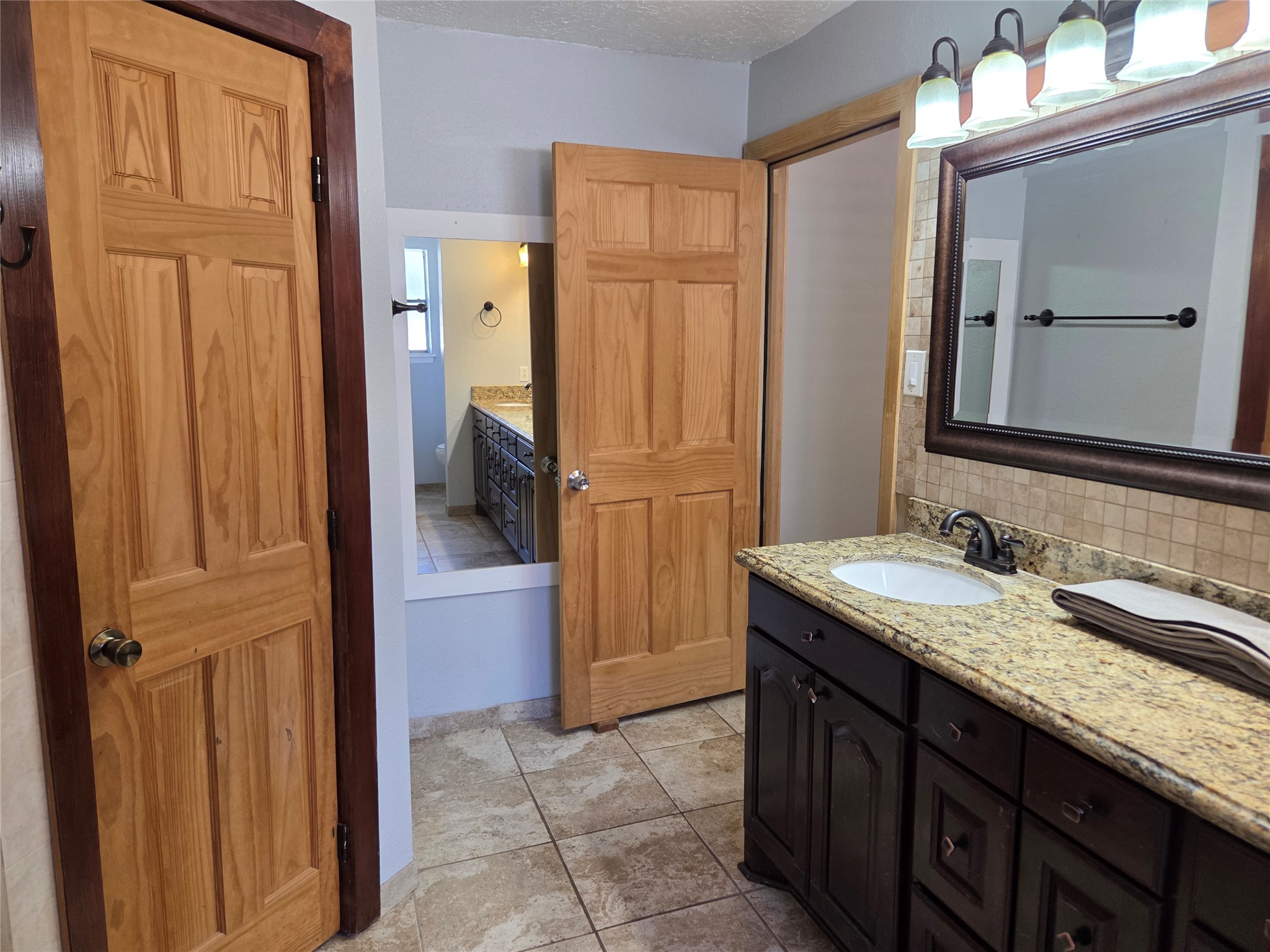 15415 Beechnut Street Houston, TX 77083 - Photo 13 of 28 a bathroom with a granite countertop sink and a mirror