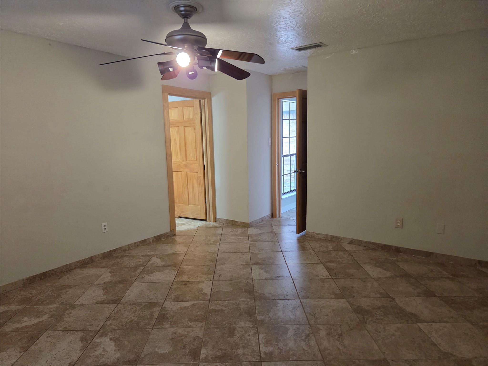 15415 Beechnut Street Houston, TX 77083 - Photo 14 of 28 a view of an empty room and chandelier fan