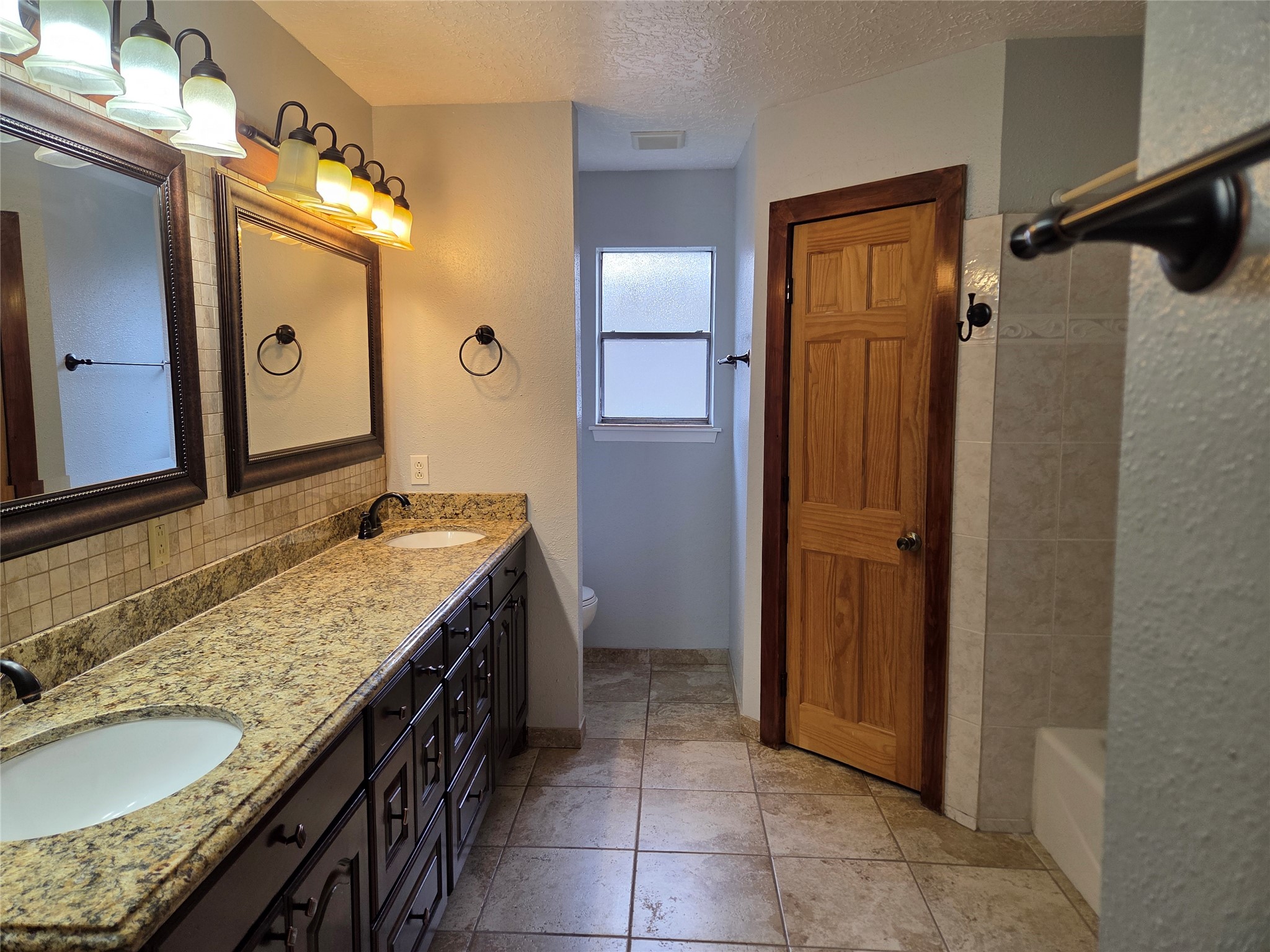 15415 Beechnut Street Houston, TX 77083 - Photo 17 of 28 a bathroom with a granite countertop sink and a mirror