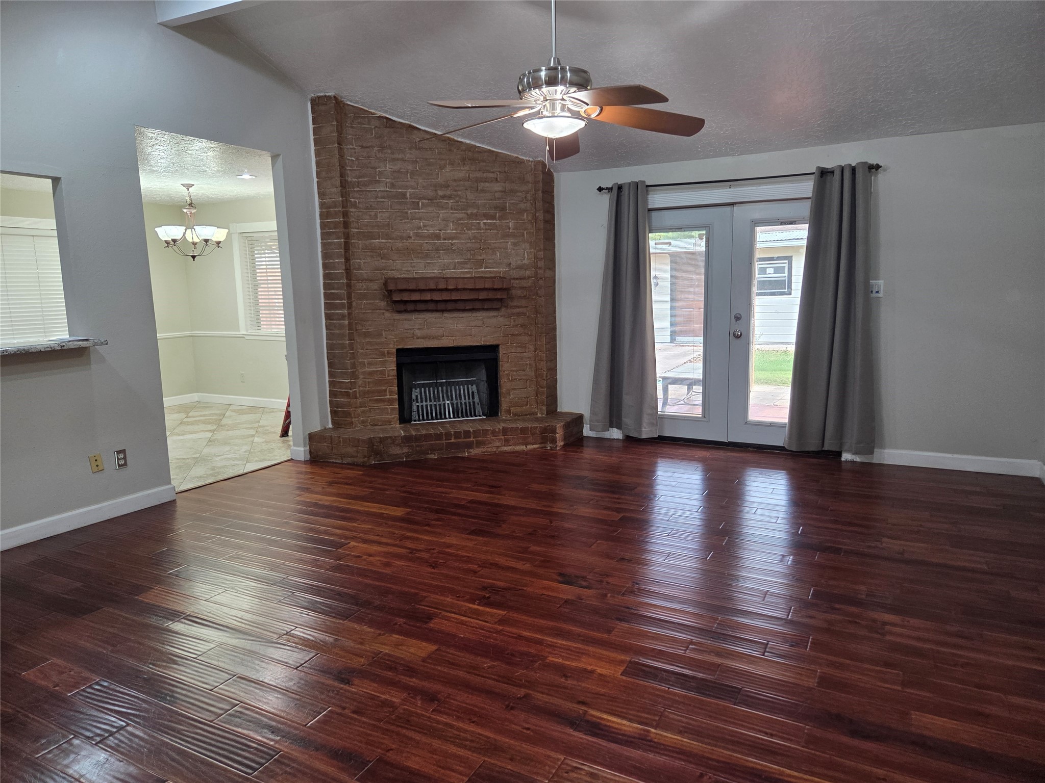 15415 Beechnut Street Houston, TX 77083 - Photo 22 of 28 an empty room with wooden floor fireplace and windows