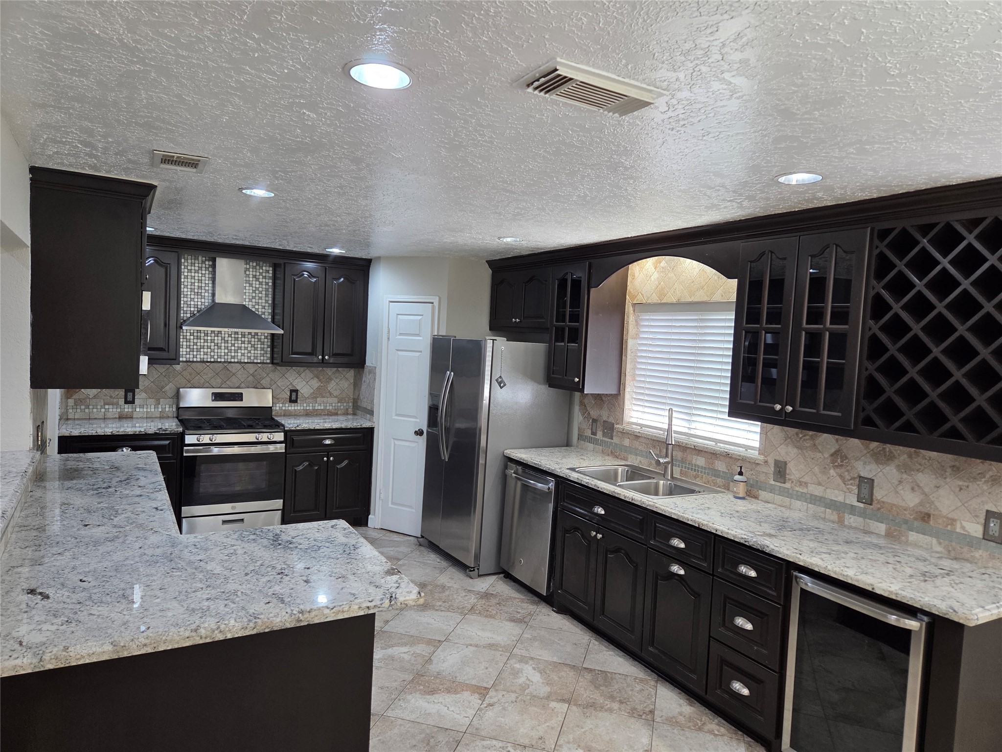 15415 Beechnut Street Houston, TX 77083 - Photo 8 of 28 a view of a kitchen counter top space a sink stainless steel appliances and cabinets