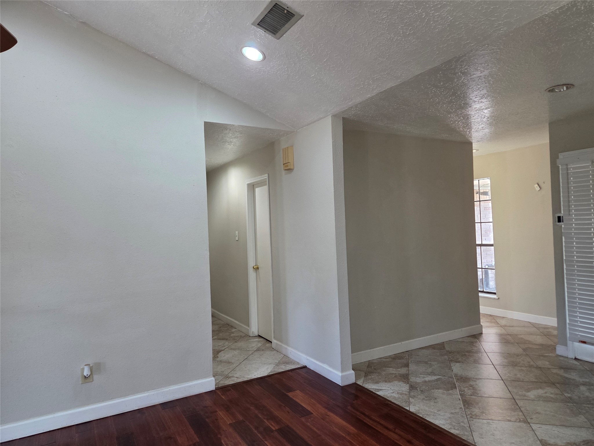 15415 Beechnut Street Houston, TX 77083 - Photo 9 of 28 an empty room with wooden floor & bathroom view