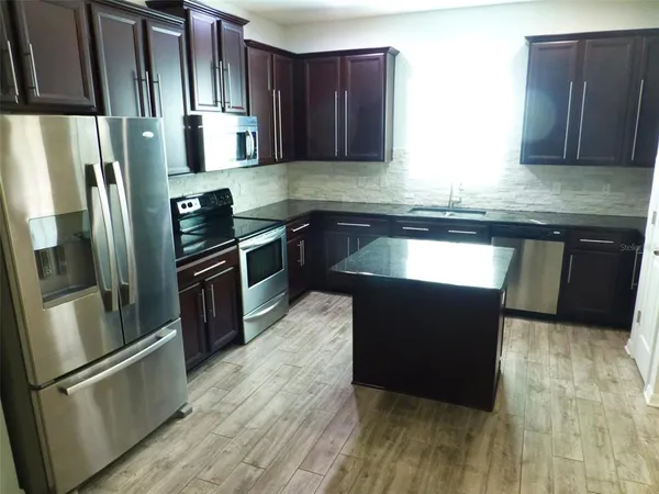 a kitchen with granite countertop stainless steel appliances and wooden cabinets