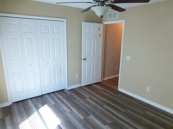 a view of empty room with wooden floor