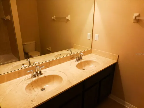 a bathroom with a sink vanity granite and a mirror