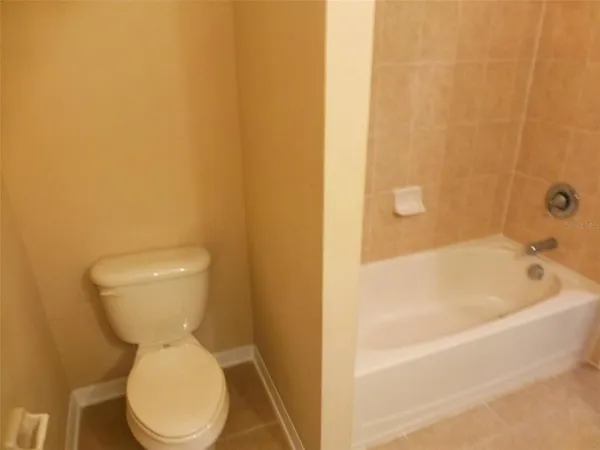 a white toilet sitting next to a white tub