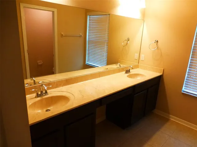a bathroom with a double vanity sink and mirror