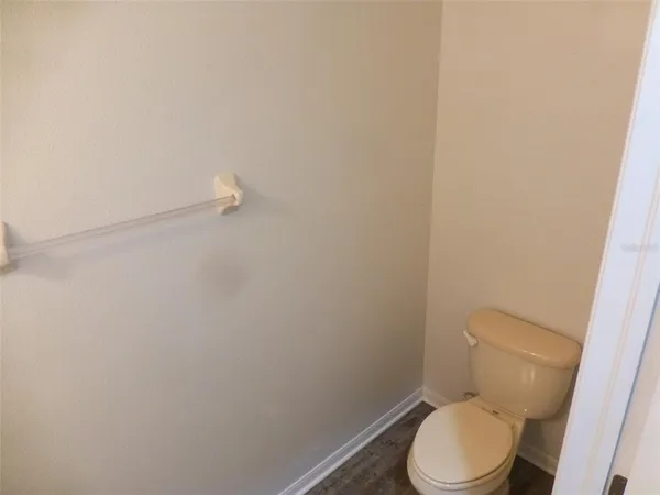 a white toilet sitting next to a white wall