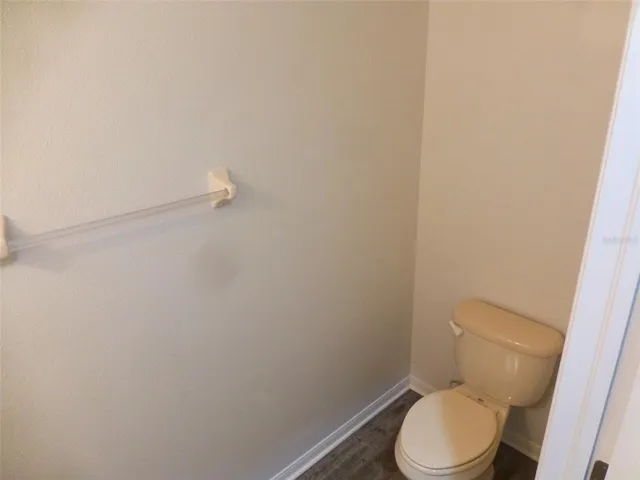 a white toilet sitting next to a white wall