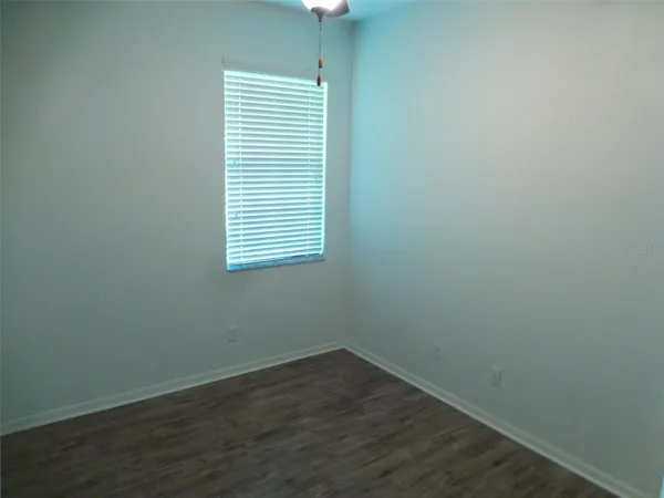 an empty room with wooden floor and a window