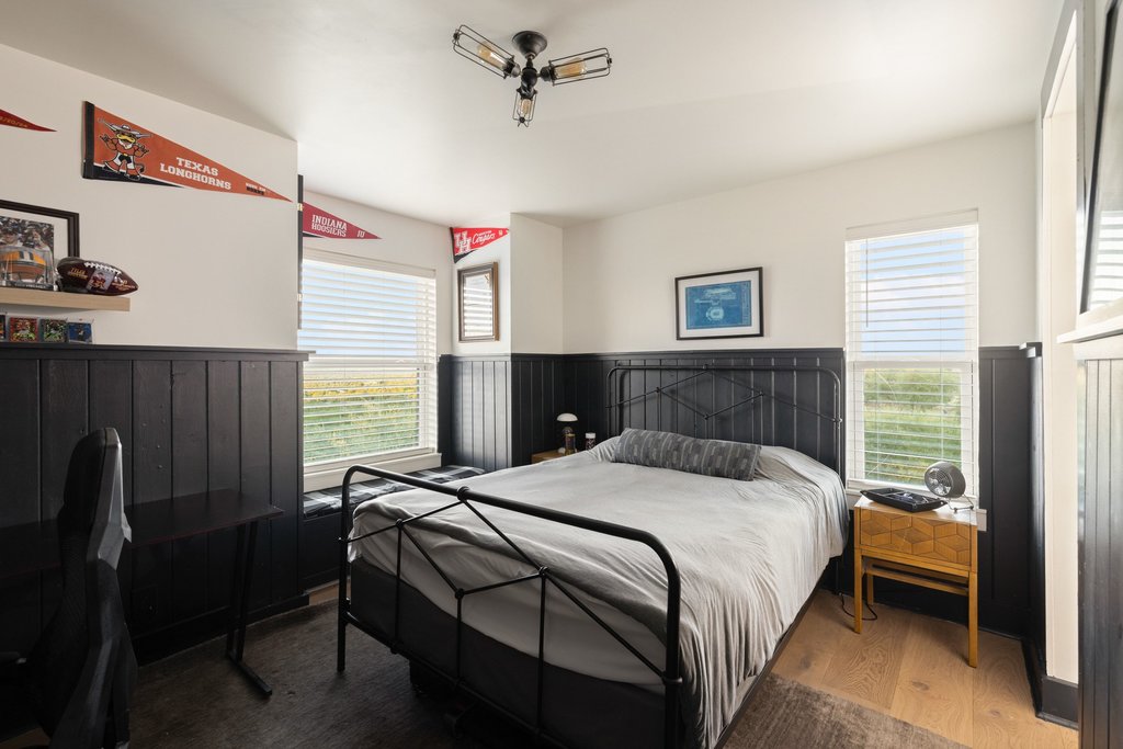 32045 Mirela Ann Road Dripping Springs, TX 78620 - Photo 20 of 30 Classic wainscoting wraps this comfortable bedroom lit by two large windows.