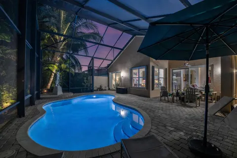a view of a swimming pool with a patio and a garden
