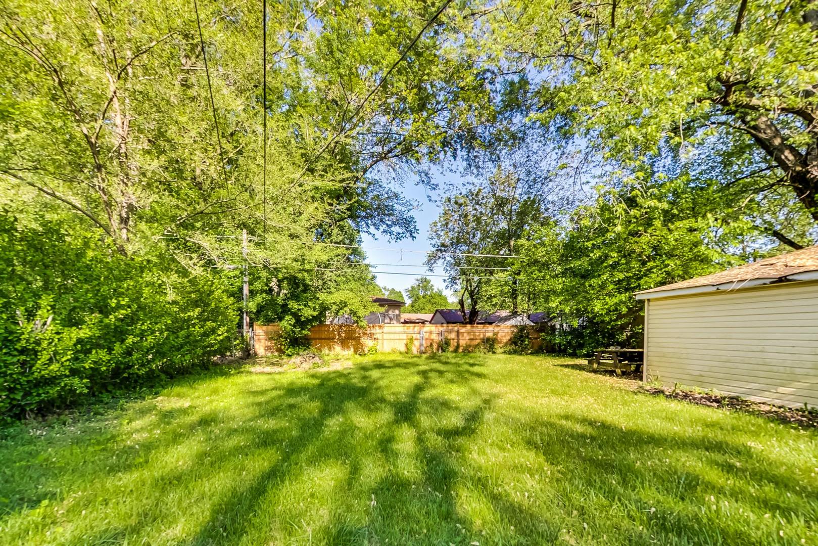 15545 Ridgeway Avenue Markham, IL 60428 - Photo 25 of 28 a backyard of a house with plants and large trees