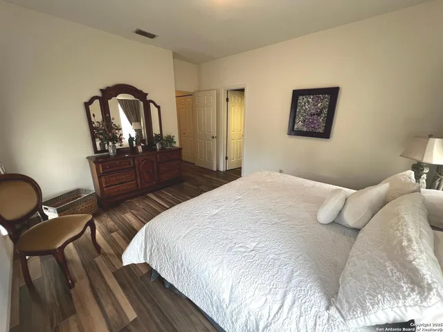 a bedroom with a bed and a dresser with mirror