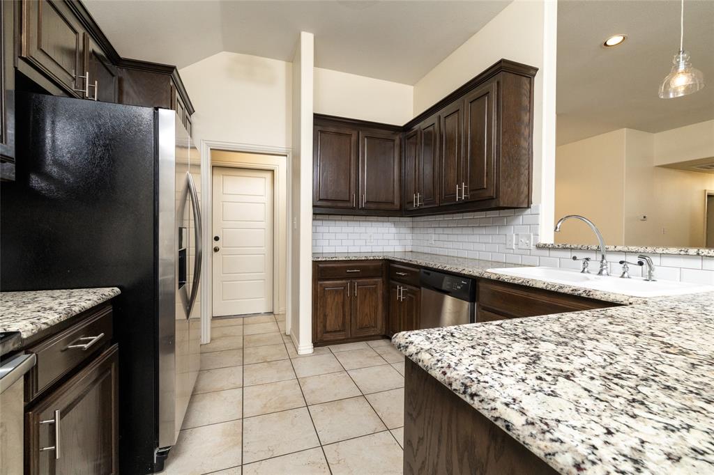 405 Kimbrough Road Azle, TX 76020 - Photo 12 of 39 a kitchen with stainless steel appliances granite countertop a sink stove and refrigerator