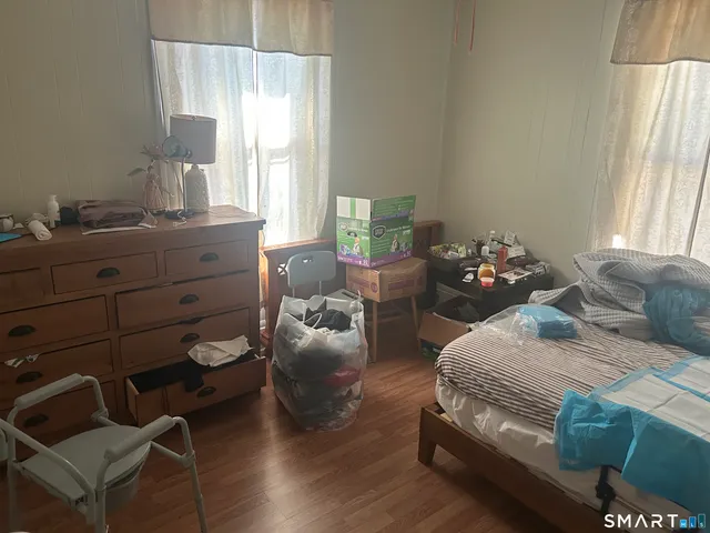 a bedroom with a bed and wooden floor