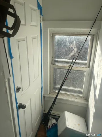 a walk in closet with wooden floor