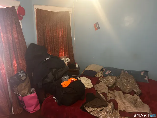 a bed sitting in a bedroom next to a window