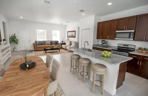 a kitchen with granite countertop a sink and a stove top oven with wooden floors
