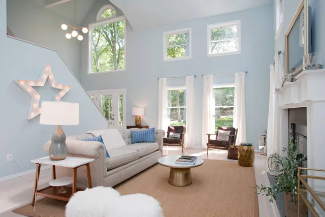 a living room with furniture a lamp and a potted plant