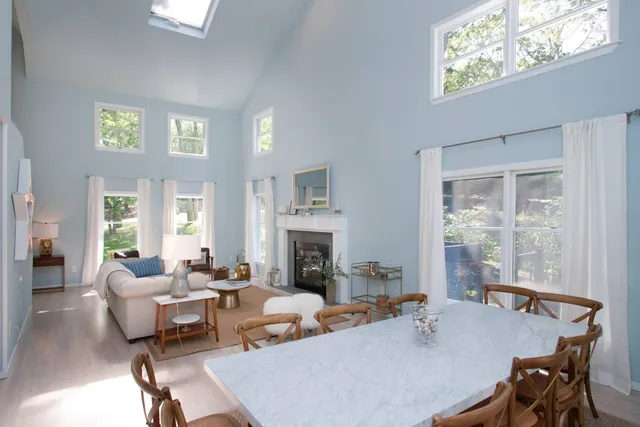 a living room with fireplace furniture and a large window