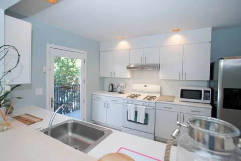 a kitchen that has a sink cabinets counter space and appliances